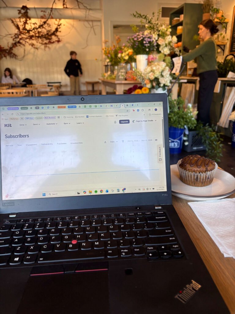 laptop and muffin in coffee shop with flowers