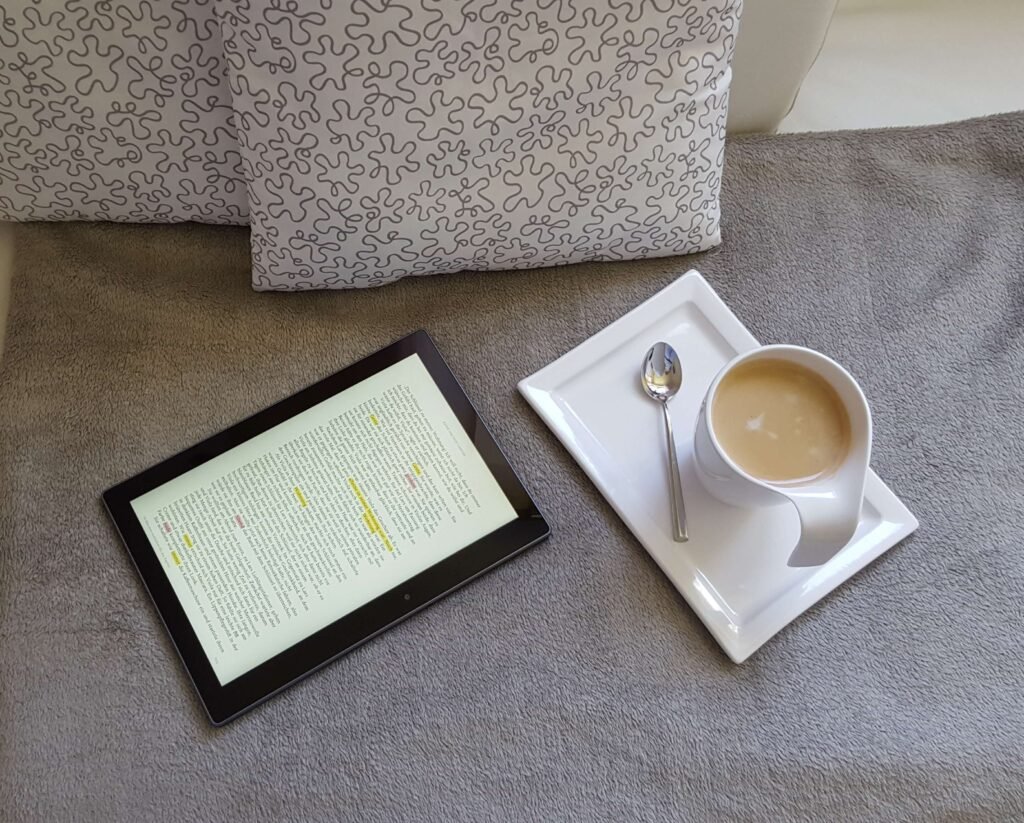 Ebook reader on bed with coffee cup