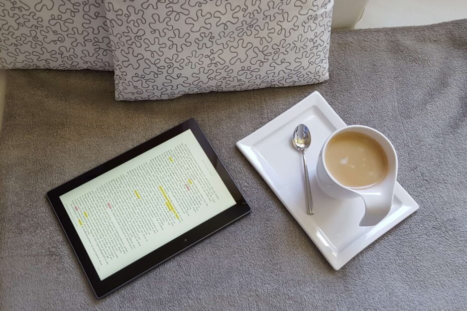 Ebook reader on bed with coffee